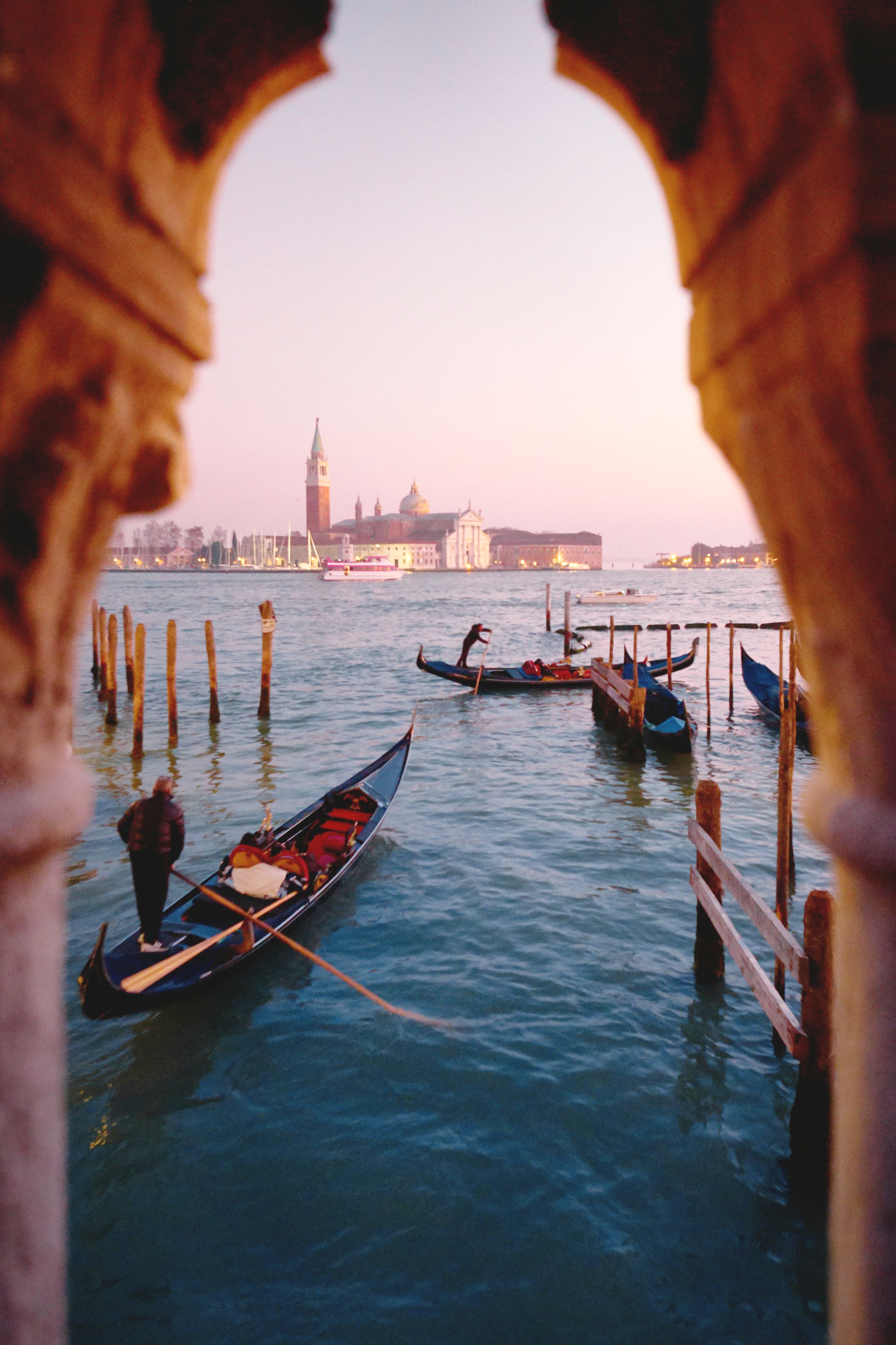 Gondolas resting along a Venetian canal at sunset